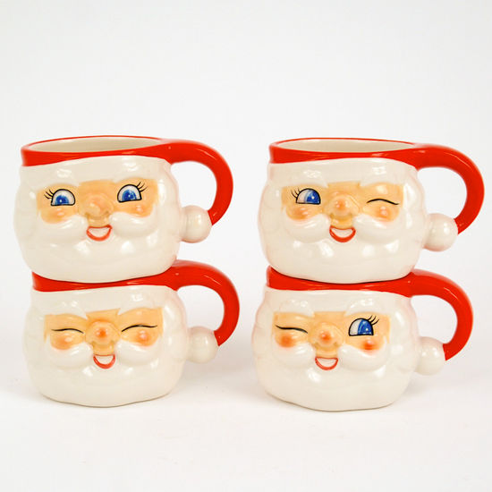 4 assorted smiling santa face mugs with his hat creating the handle
