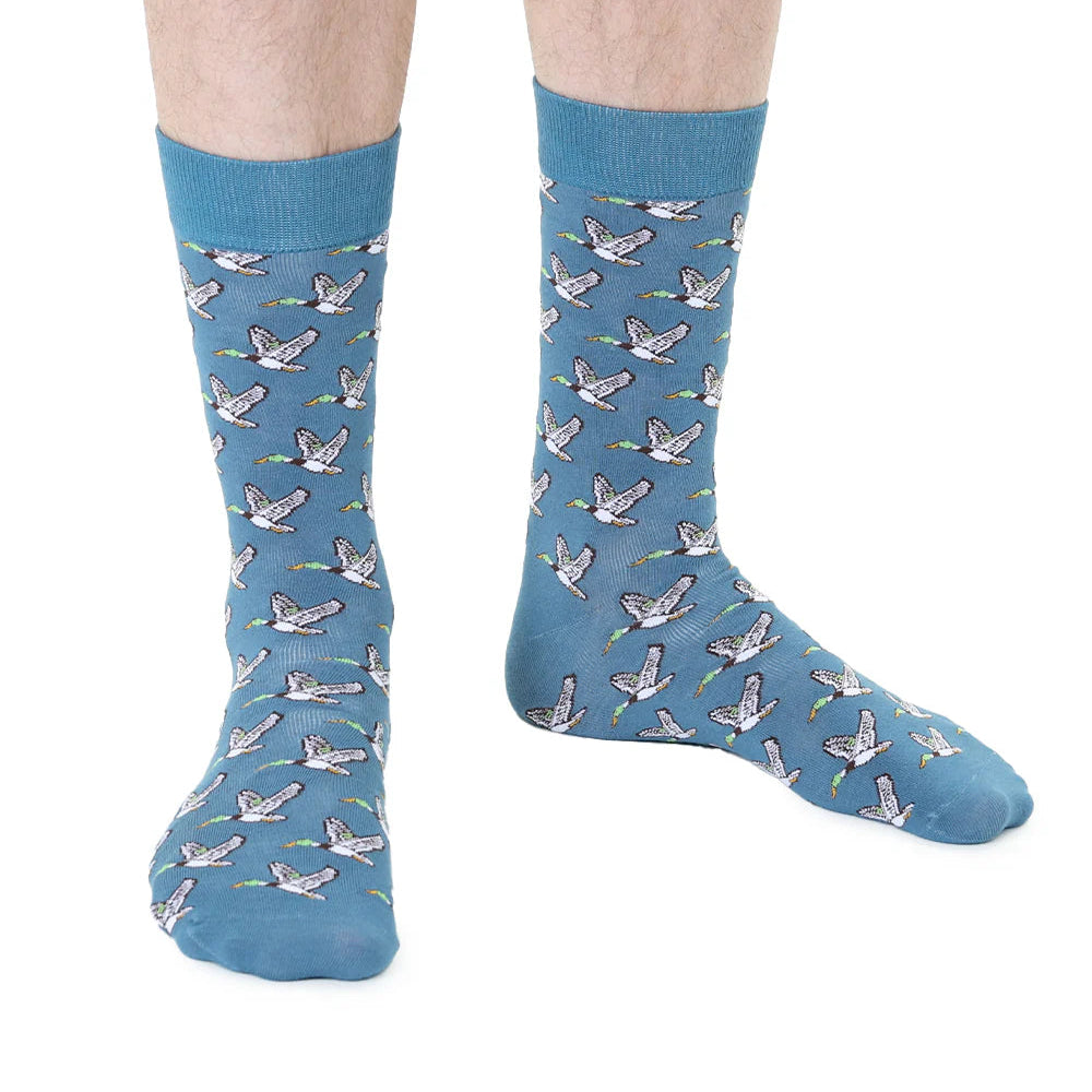 Blue socks with duck pattern worn by a person on a white background