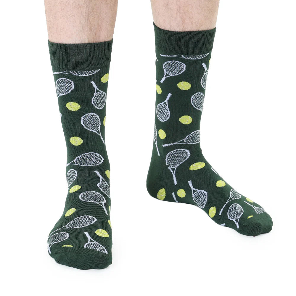 Green socks with tennis racket and ball pattern worn by a person on a white background