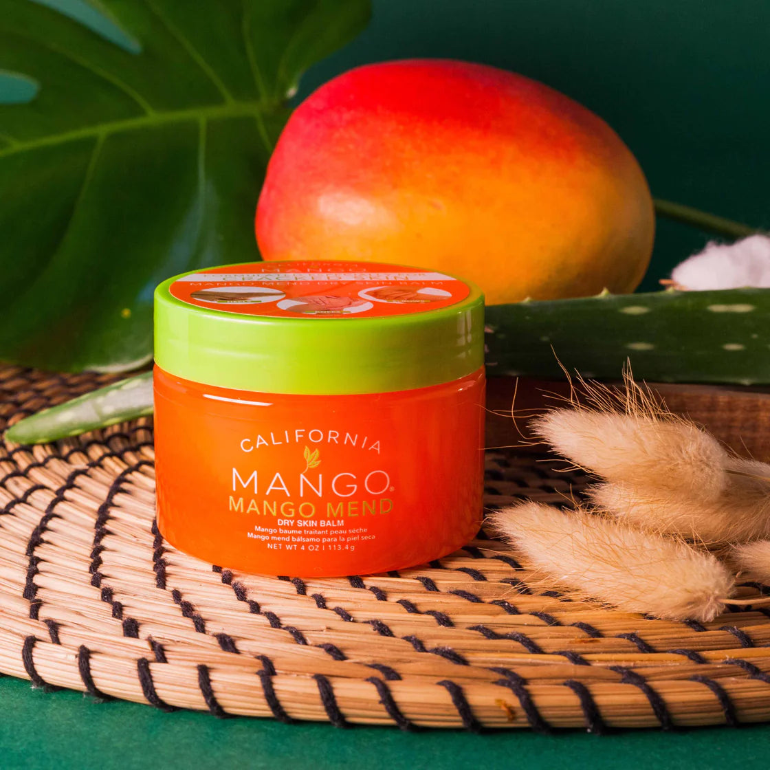 Jar of California Mango product on a woven mat with a mango in the background