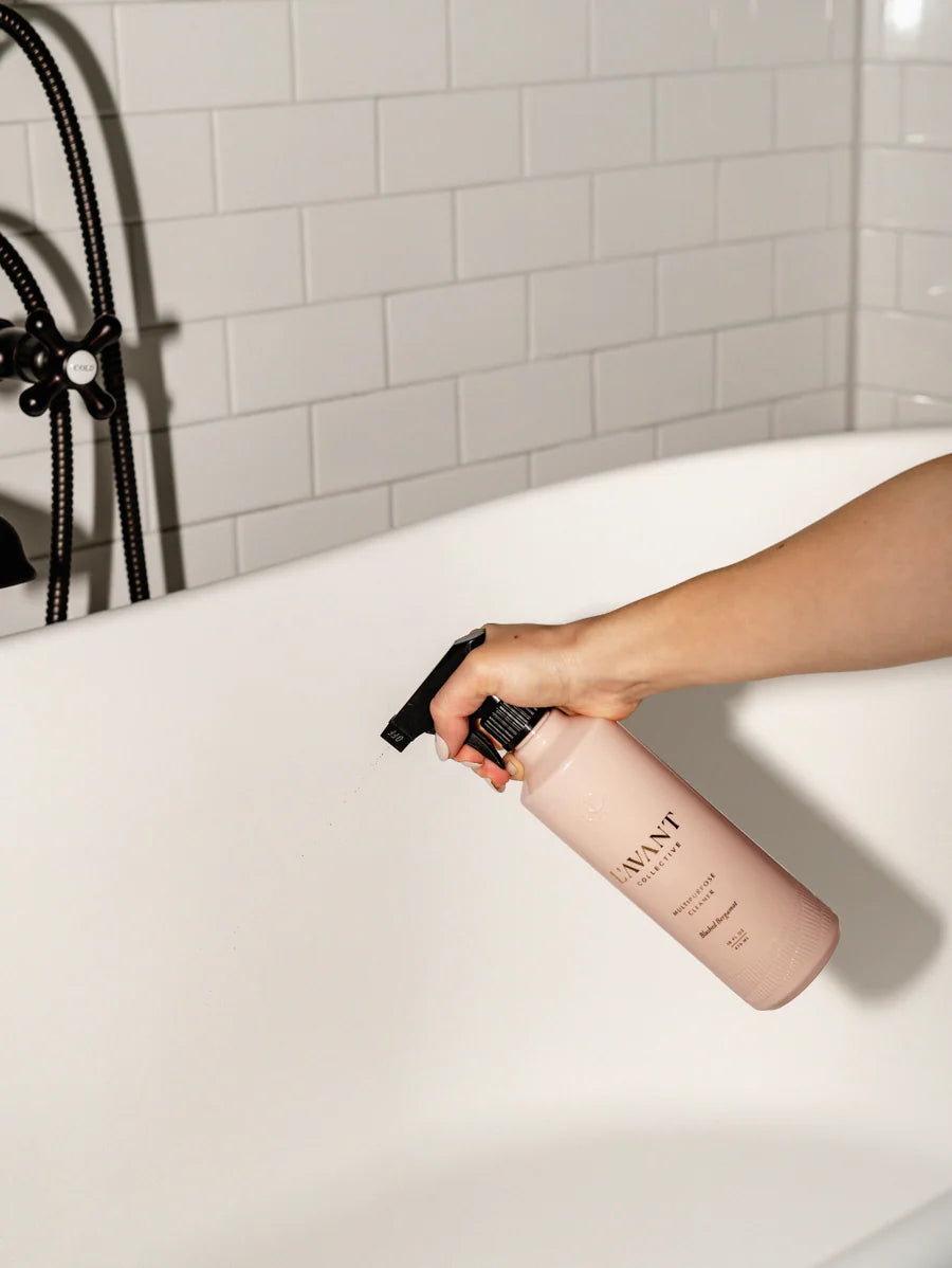 a person using the blushed bergamot multipurpose cleaner to clean a tub