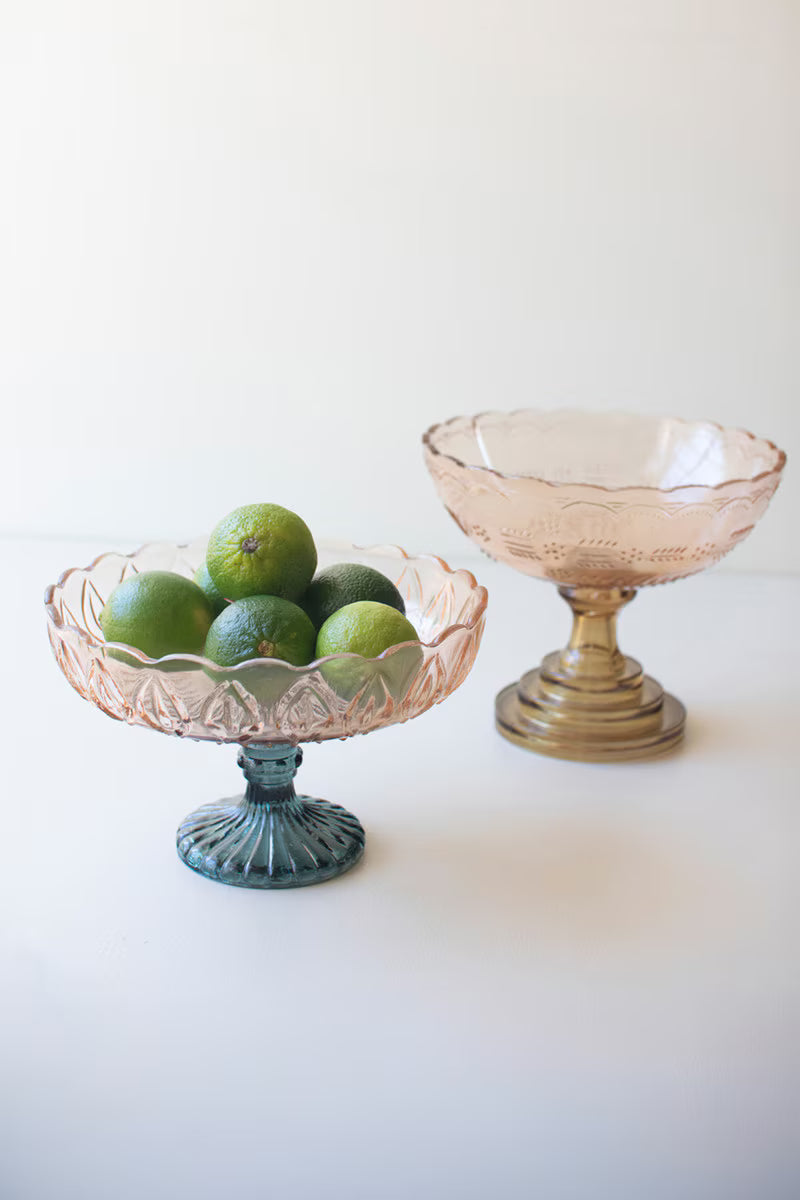 2 blush glass compotes with blue or green pedestals shown on white background
