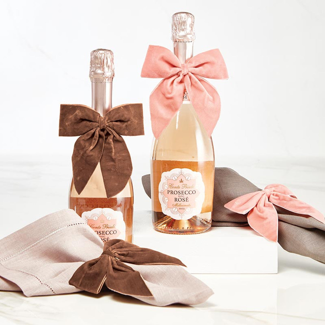 velvet bow napkin rings tied on napkins and wine bottles