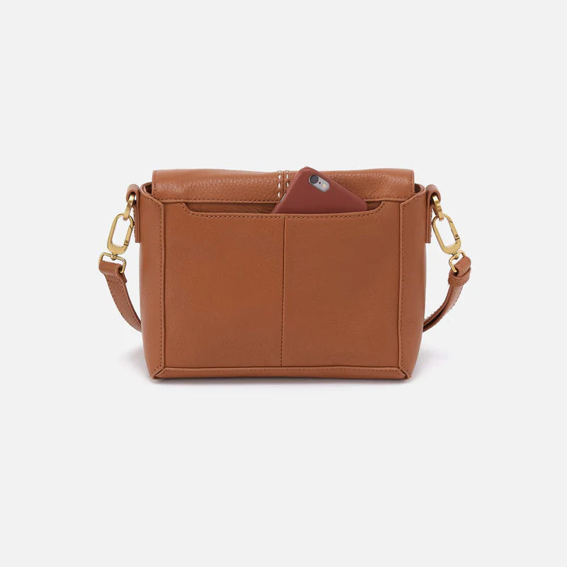 Back view of warm honey Austin flap crossbody with phone in pocket