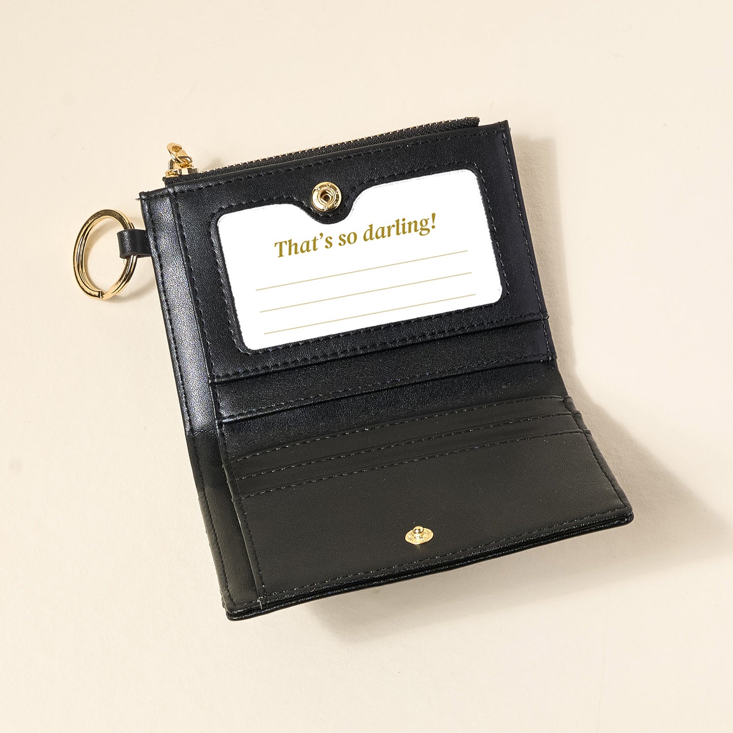 black luxe pocket wallet opened up on a beige background