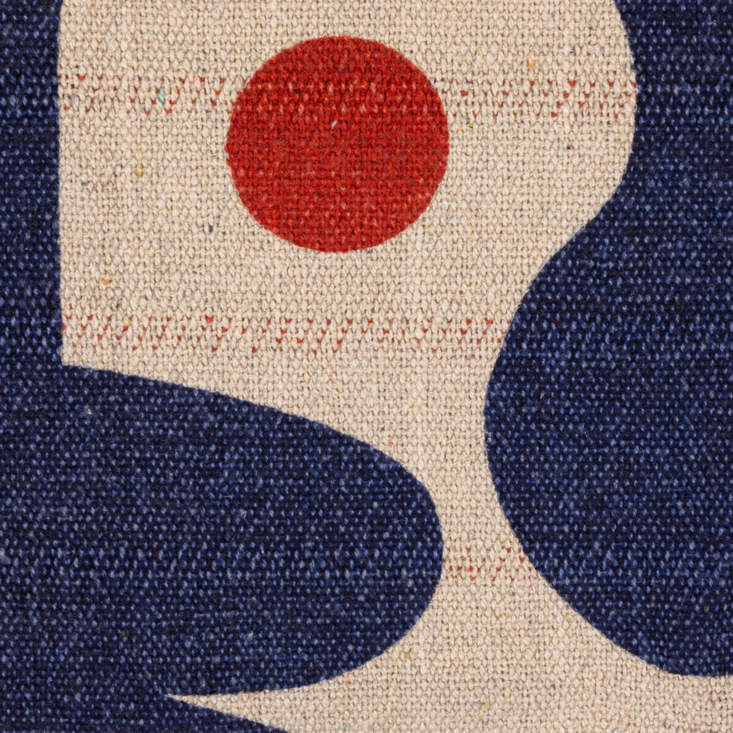Close-up of a fabric with a orange dot and blue shapes.