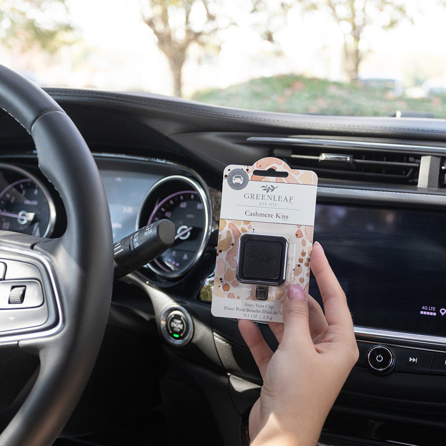person in car holding Cashmere Kiss Auto Vent Clip.