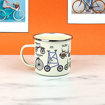 bike enameled mug set on a desk with an orange background.