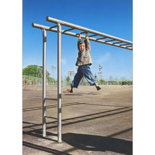 front of card is a little boy hanging on monkey bars on a playground