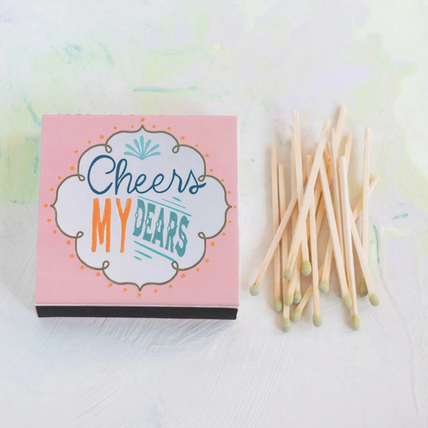 matches outside of a pink matchbox that says cheers my dears