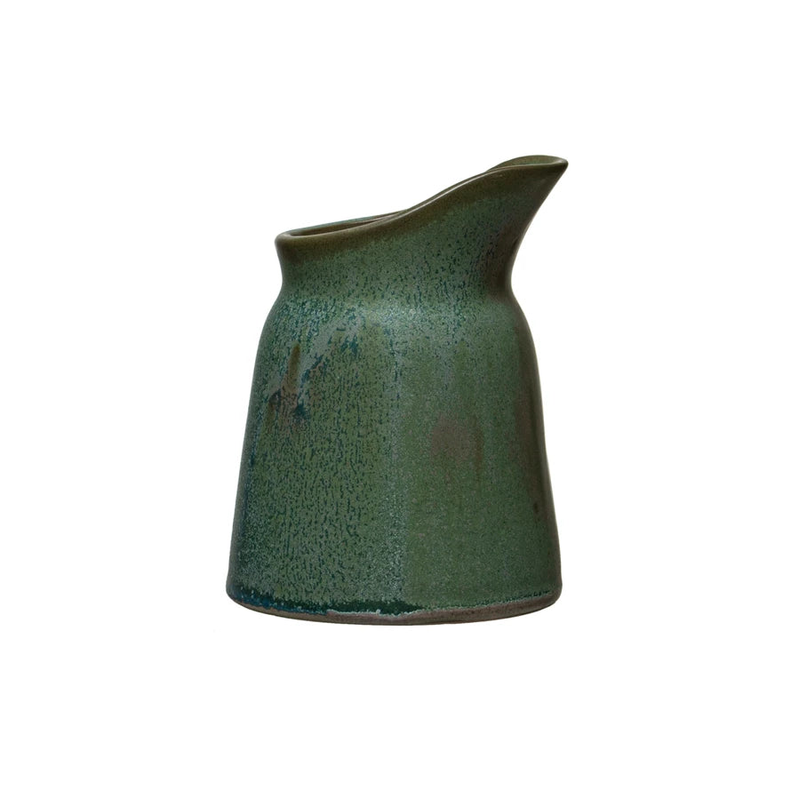 green stoneware creamer shown on a white background
