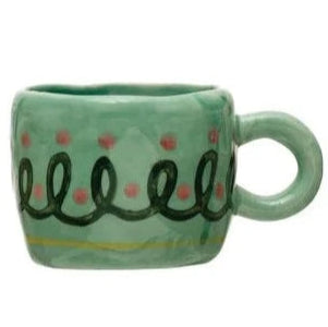green mug with swirl and dot apttern.