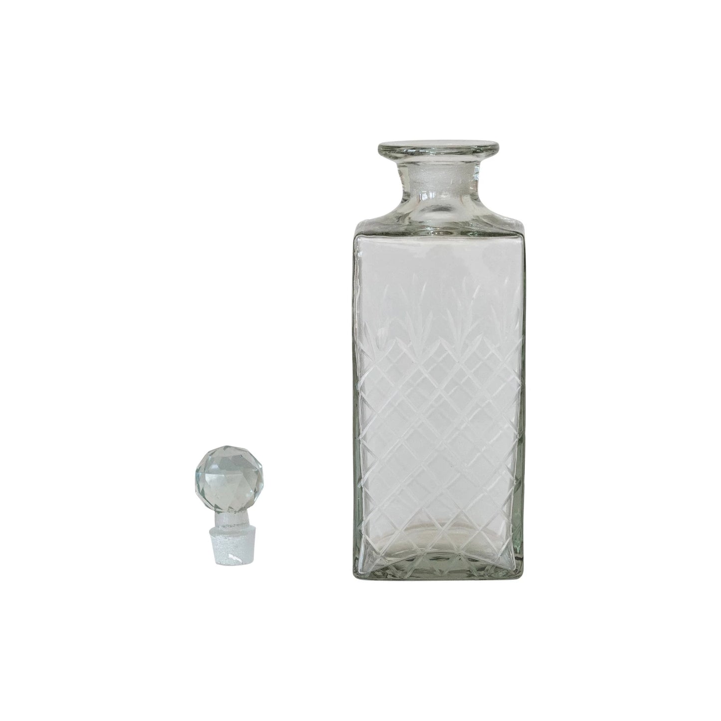 Clear glass bottle with diamond pattern and matching stopper on a white background