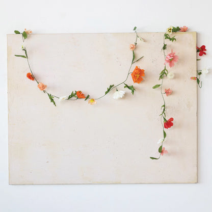 paper flower garlands draped along an off-white background.