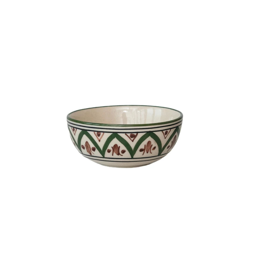 A hand-painted stoneware bowl with a beige, green, and brown floral pattern.