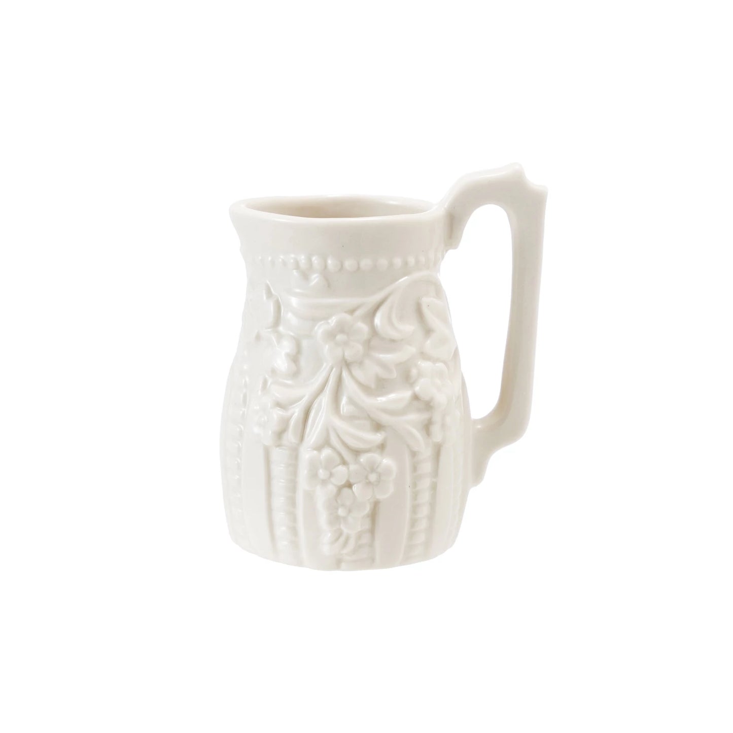 White ceramic creamer pitcher with decorative patterns on a white background