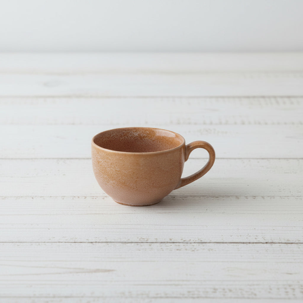 coral colored ceramic mug on a white textured surface
