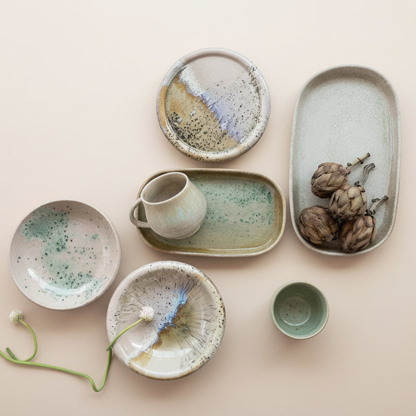 Collection of ceramic dishes and bowls on a beige background