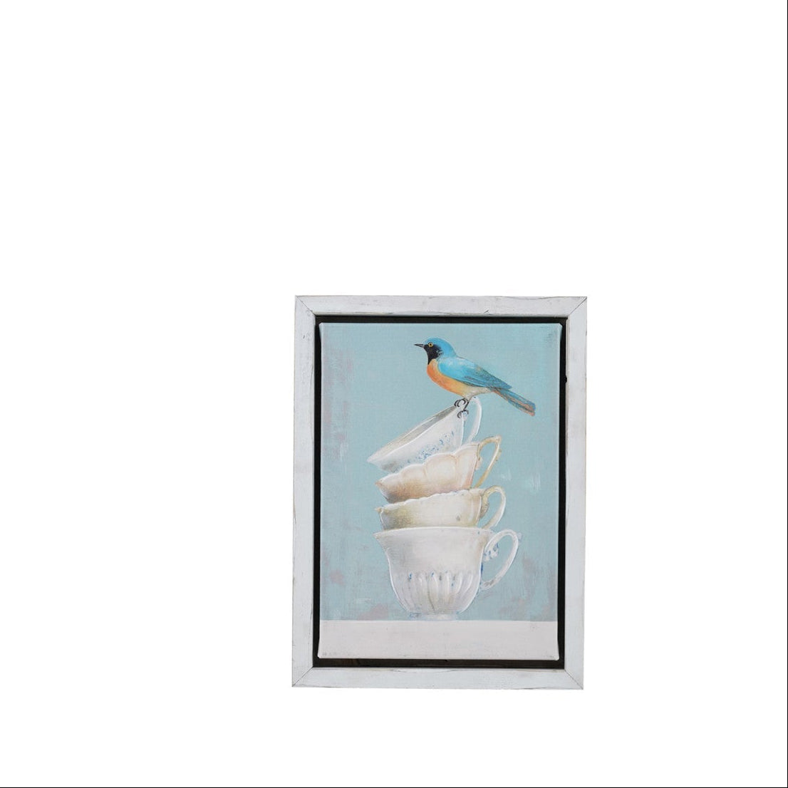framed art print featuring a small bluebird perched on a stack of white teacups against a light blue background, enclosed in a white frame with a black inner border.