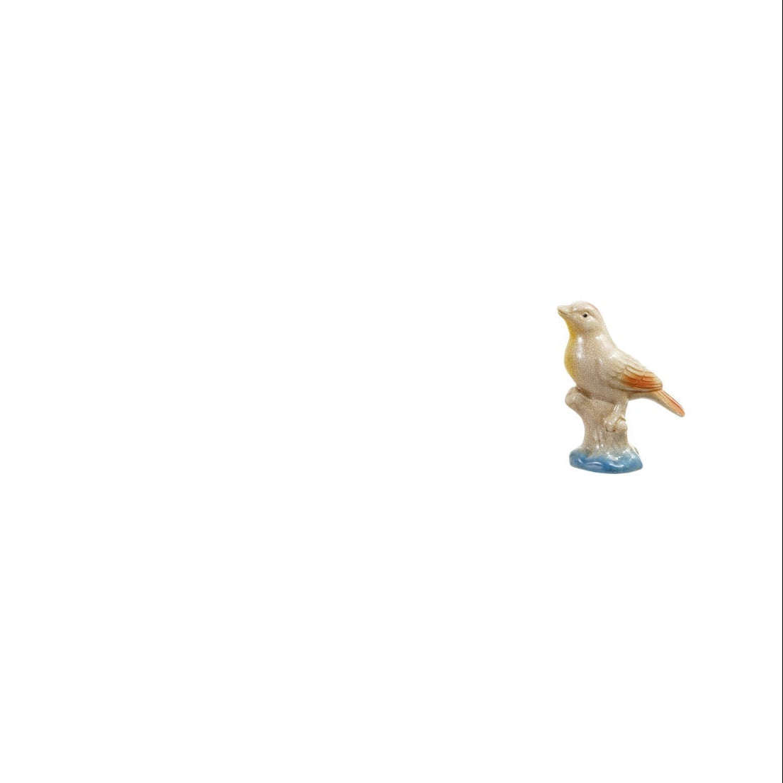 ceramic vase shaped like white and orange bird perched on a stump
