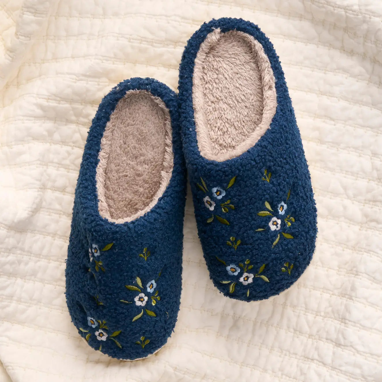 Navy Dainty Floral slippers set on a blanket