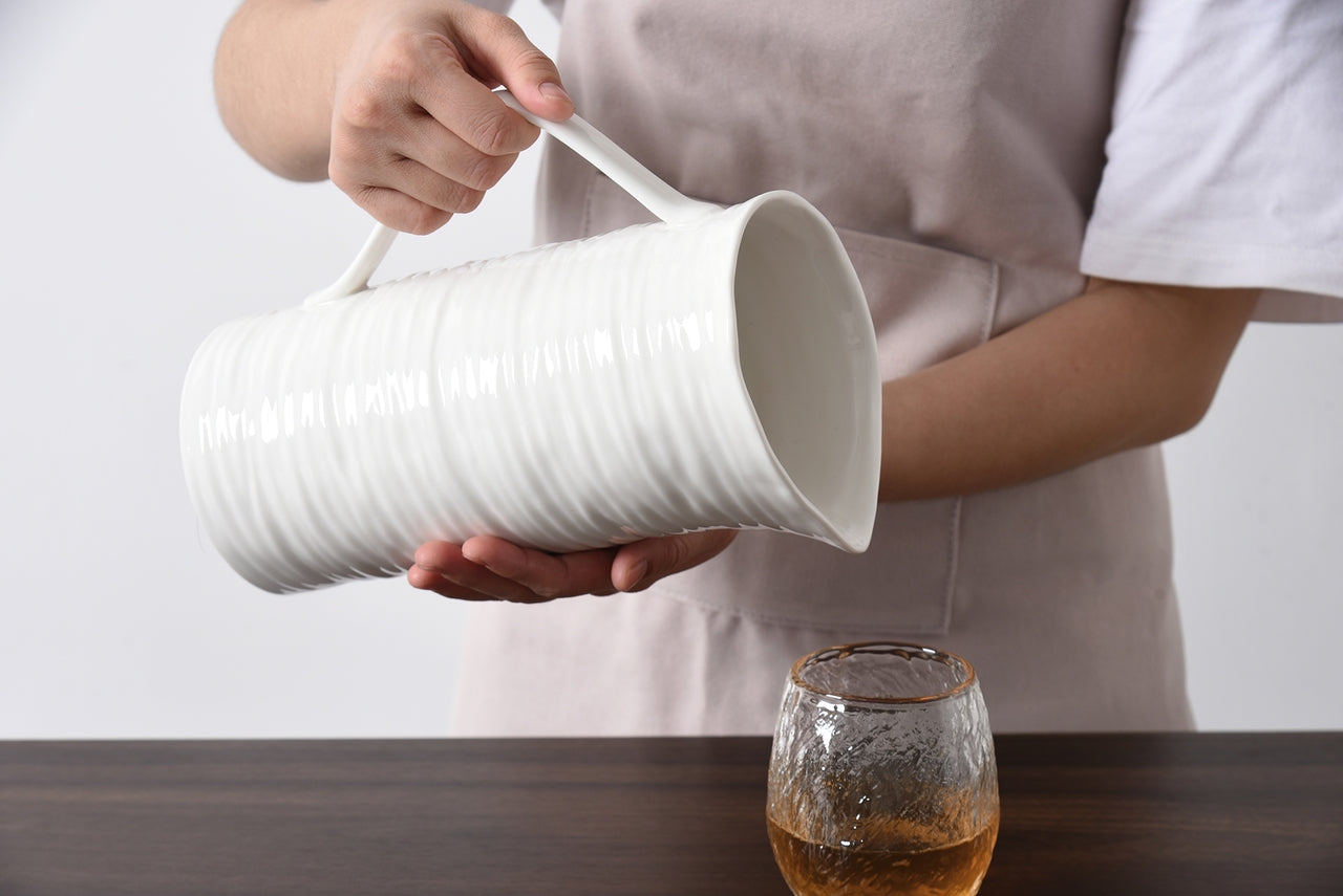 pitcher being held and pouring into a cup