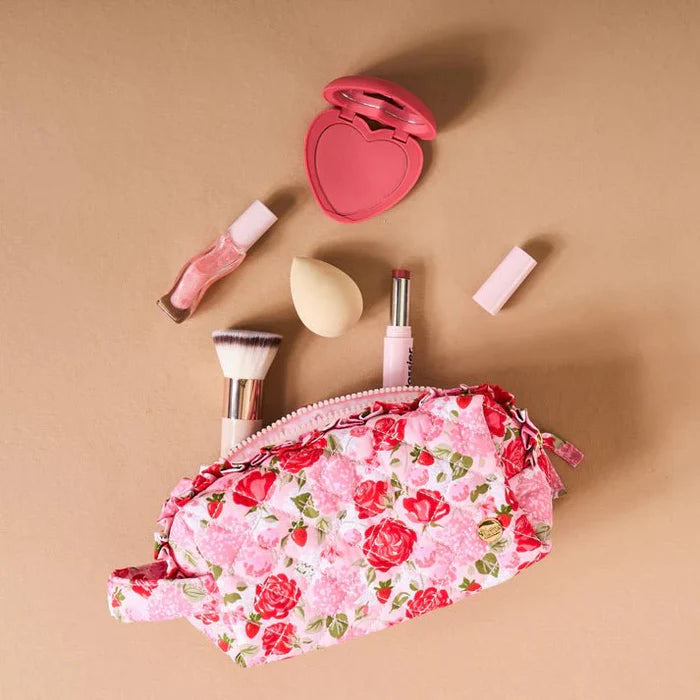 pink and red floral bag surrounded by make-up items