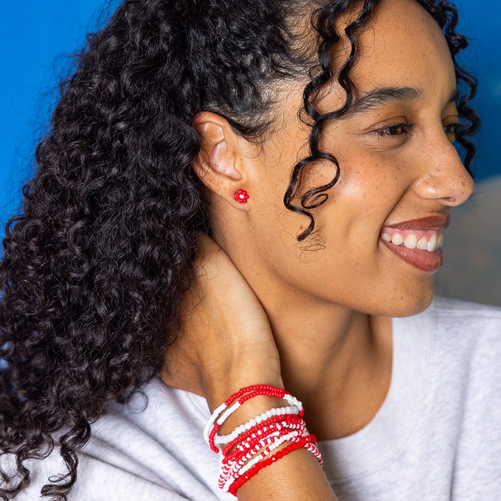 smiling person wearing red flower earrings