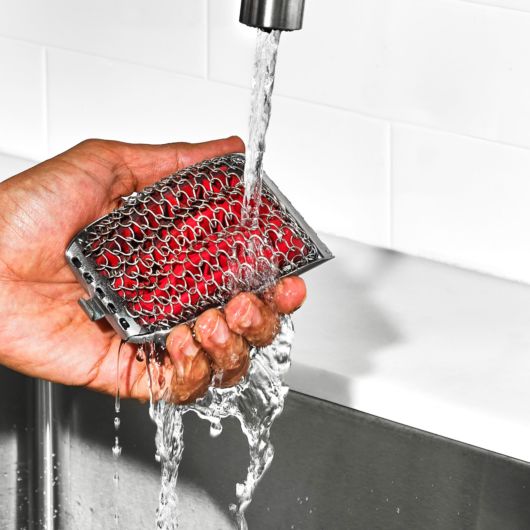 a mans had illustrating cleaning the replacement head at the sink