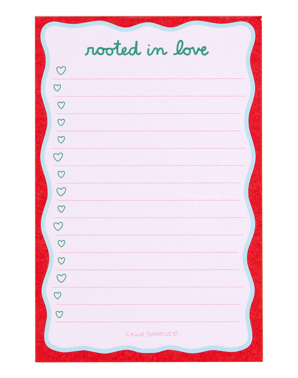 Notepad with 'rooted in love' text with pink lines and red boarder