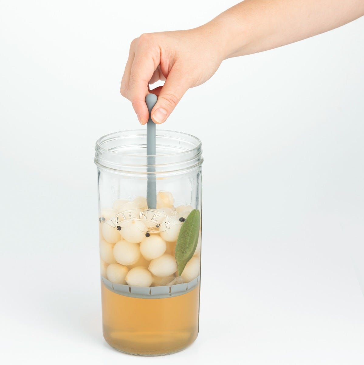 hand pulling pickled onions out of jar with lifter.