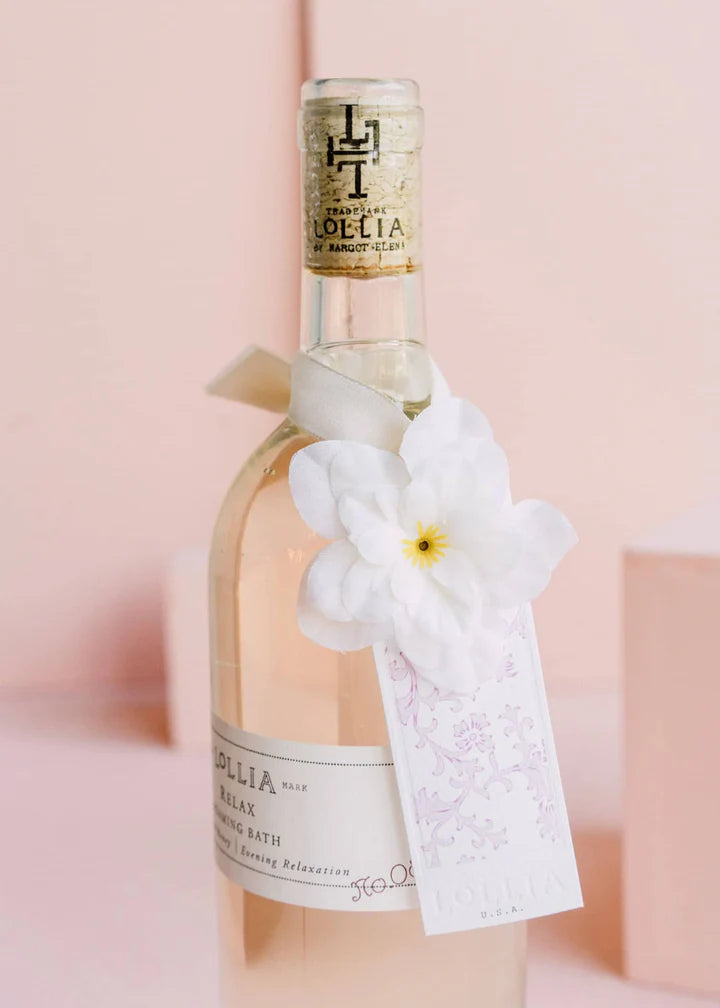 Close up of flower and tag tied around the neck of relaxed bubble bath bottle.