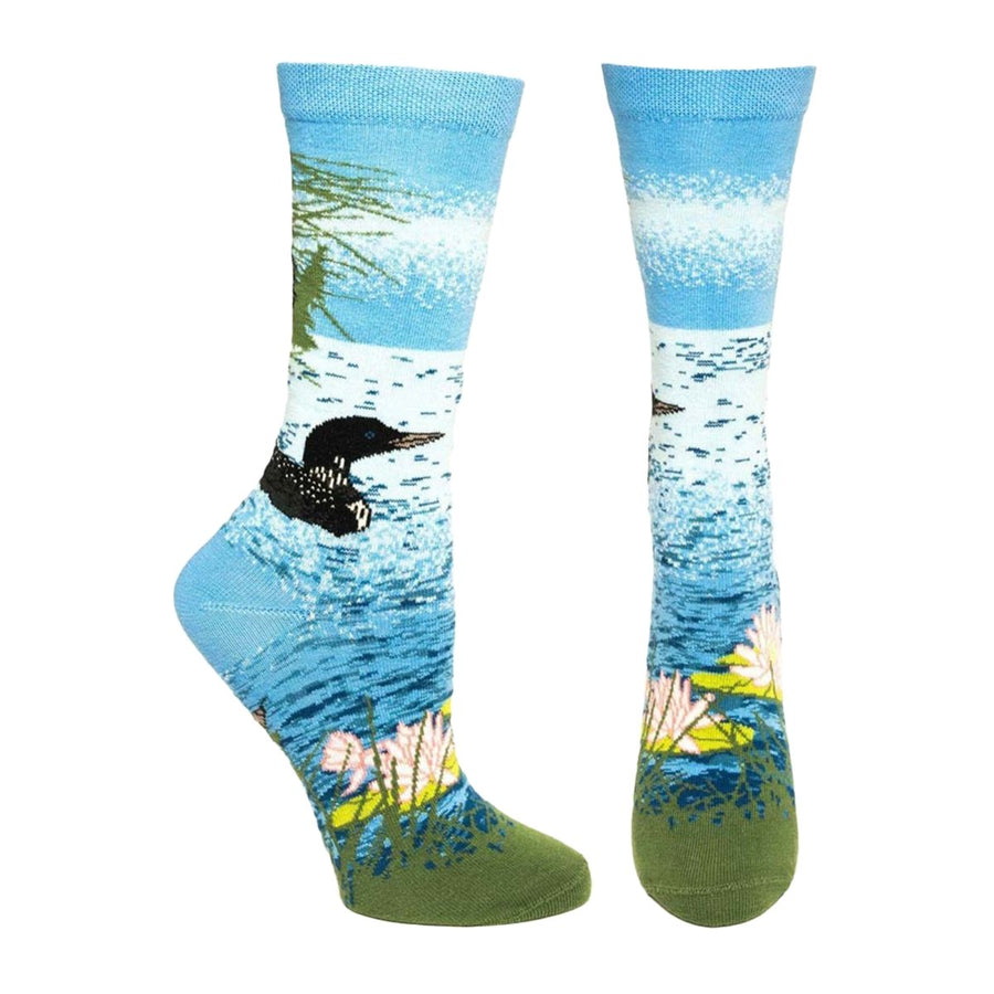 blue sock with scene of a lake with florals and a bird in the water.