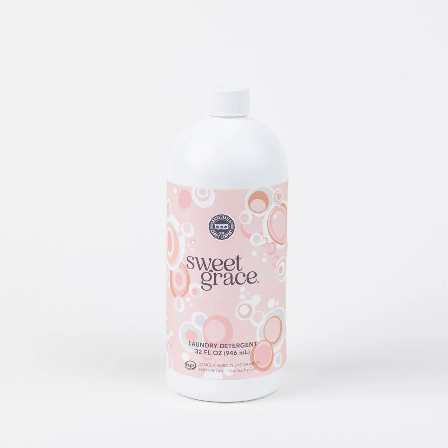 bottle of Sweet Grace Laundry Detergent on a clean white background. The bottle is white with a pink label featuring a bubble pattern