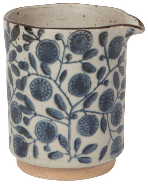 off-white speckled cream pitcher with blue floral pattern.