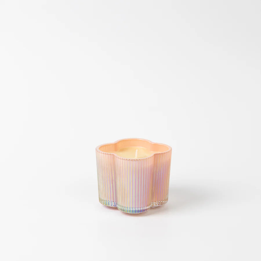 Iridescent pink glass candle on a white background