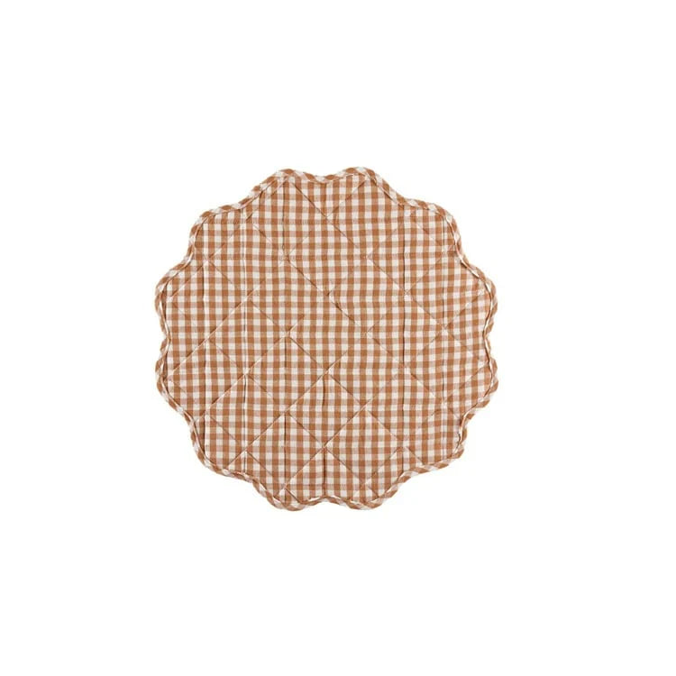 Round quilted placemat with brown and white checkered pattern on a white background