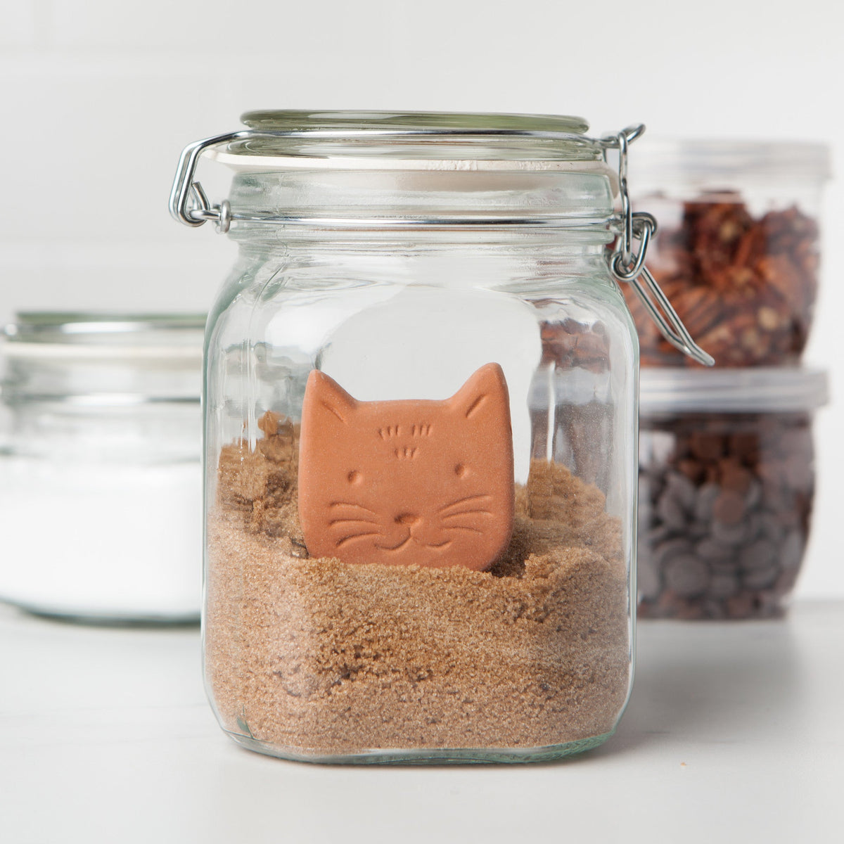 brown sugar saver shaped like a cat head in a mason jar of brown sugar