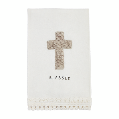 off-white tea towel with crochet trim, cross, and "blessed" on it.