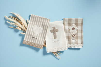 3 styles of tea towels arranged on a light blue background with dried wheat stems.