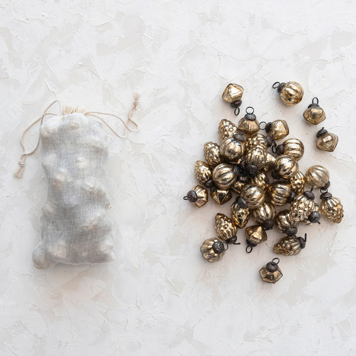pile of antique gold ornaments next to a bag full of ornaments