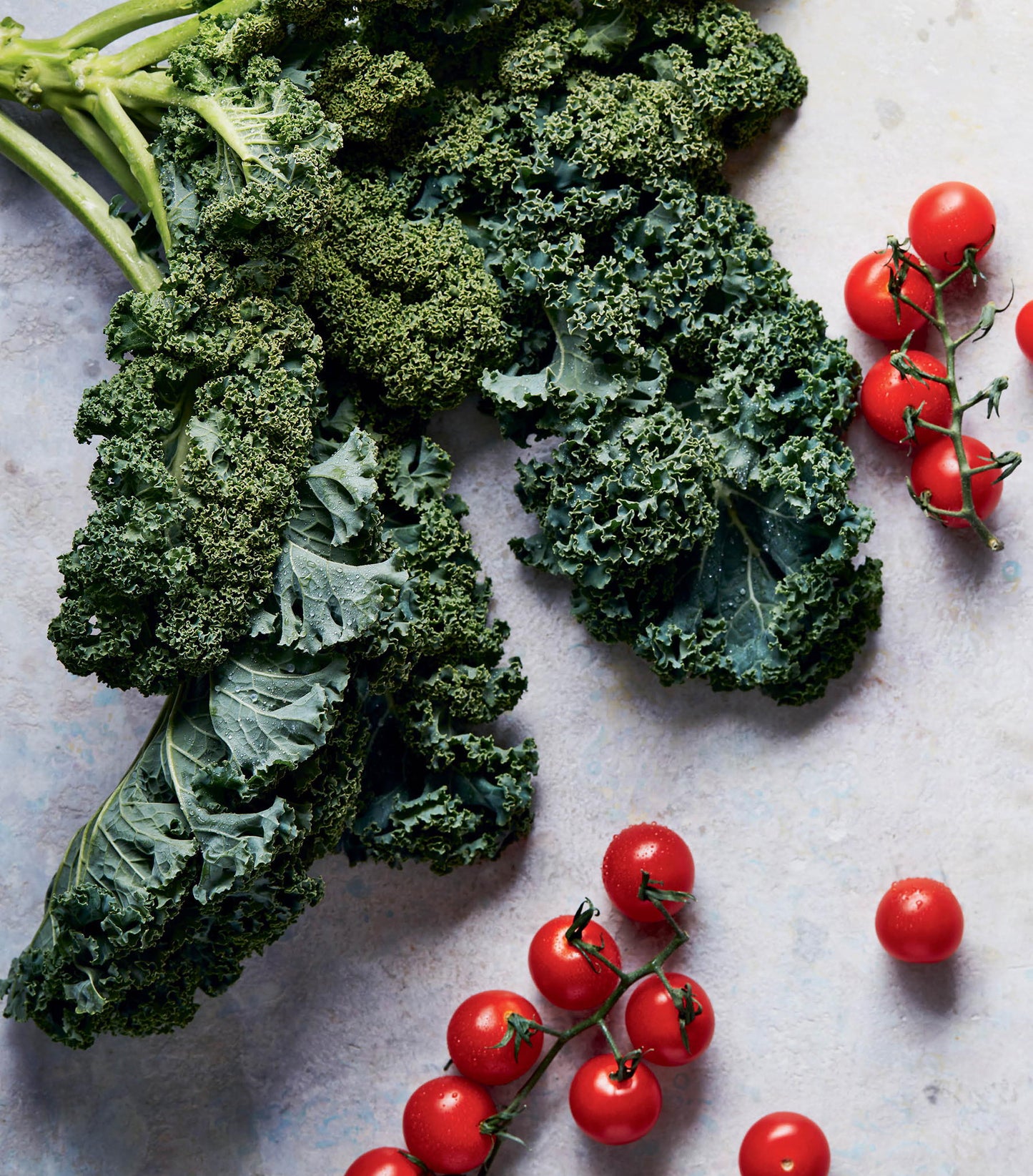 a picture inside of kale and cherry tomatoes on the vine