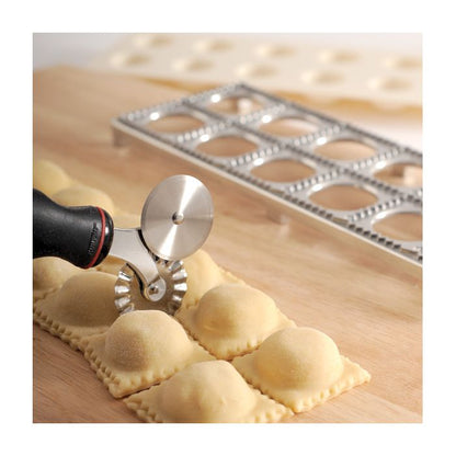 pastry wheel cutting ravioli with scalloped blade.