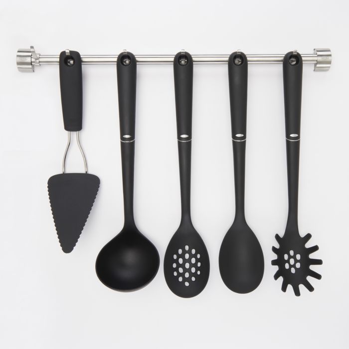 assorted black nylon utensils hanging from utensil bar.