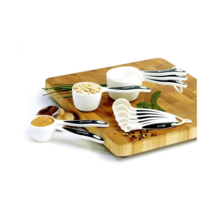 measuring cups and spoons on cutting board, 2 cups are filled with oats or brown sugar.