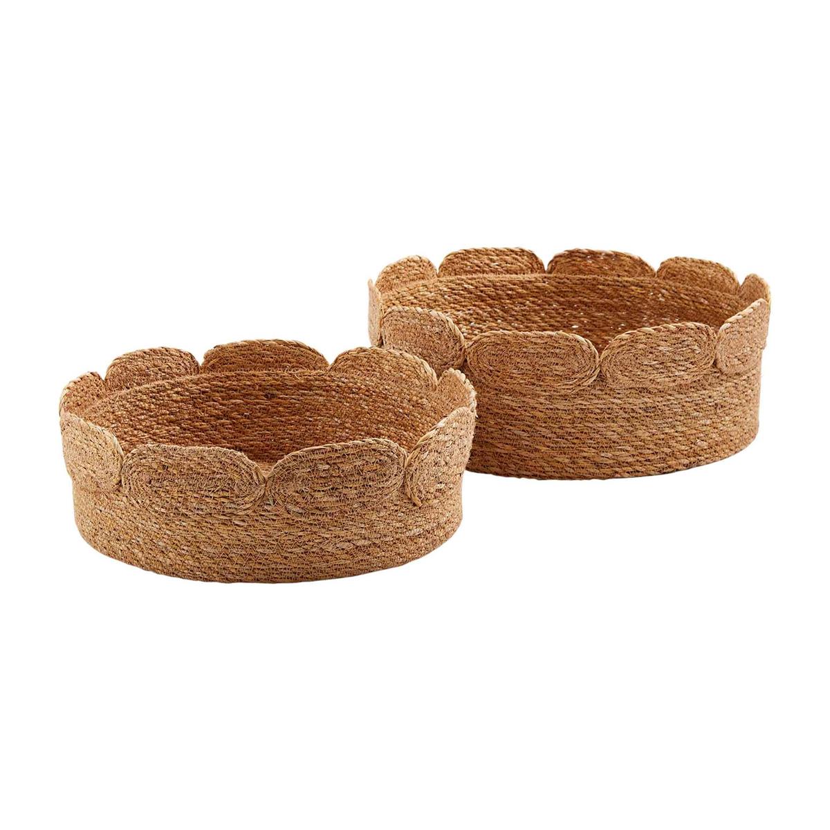 small and large scalloped jute baskets set beside each other against a white background