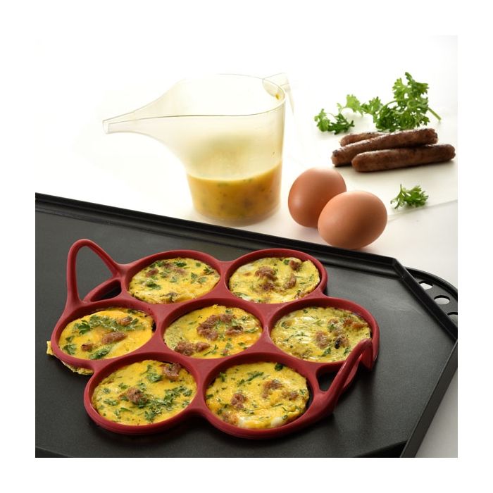 silicone pancake rings on griddle filled with eggs.