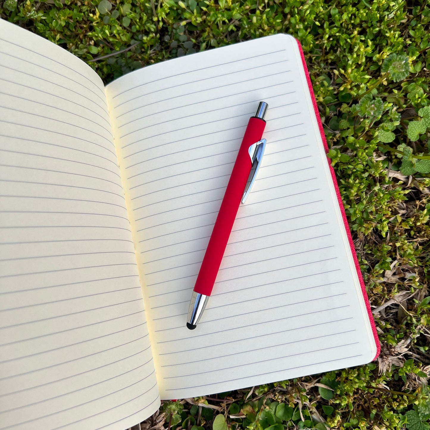 open journal with red pen laying on the lined pages.
