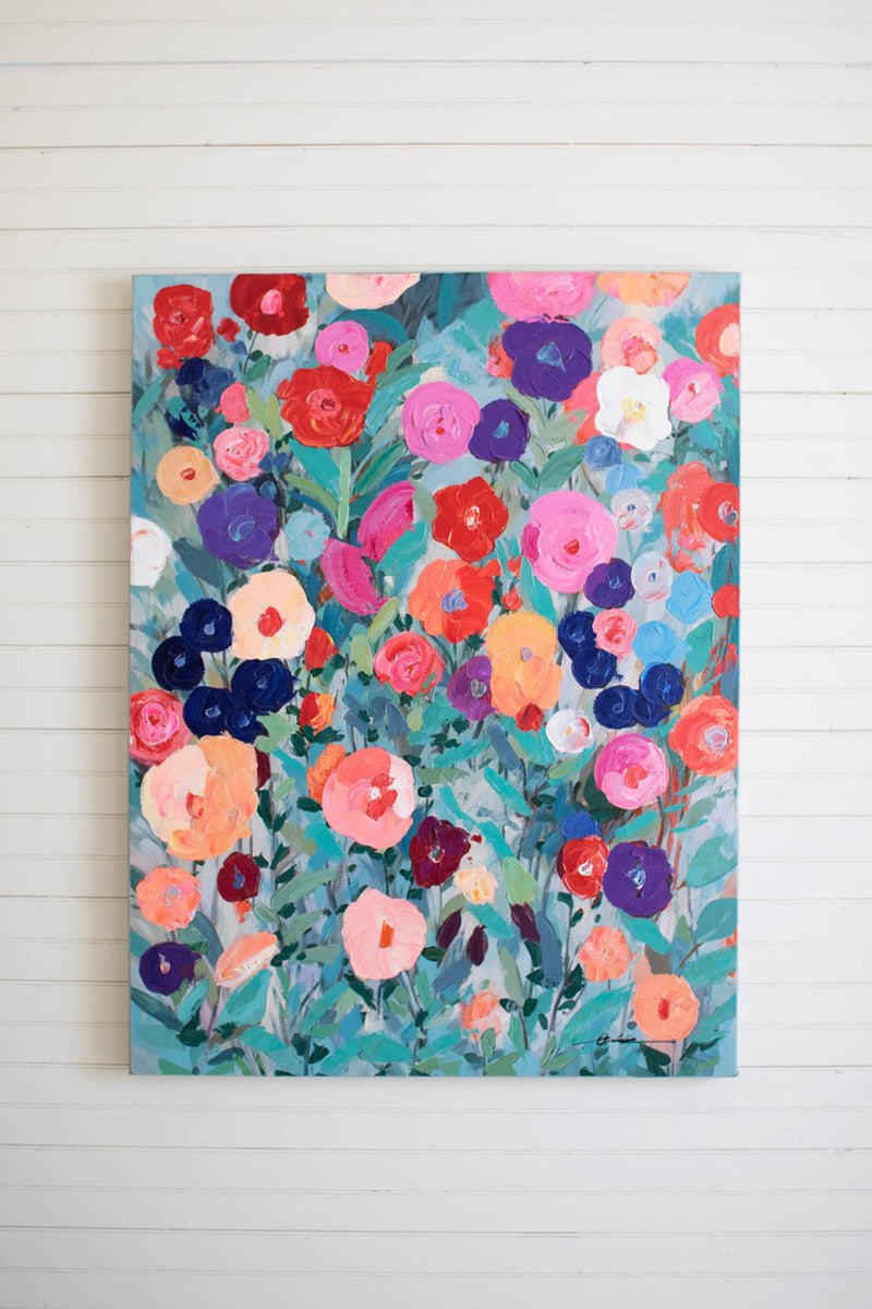 canvas painting with colorful flowers hanging on a slat wall.