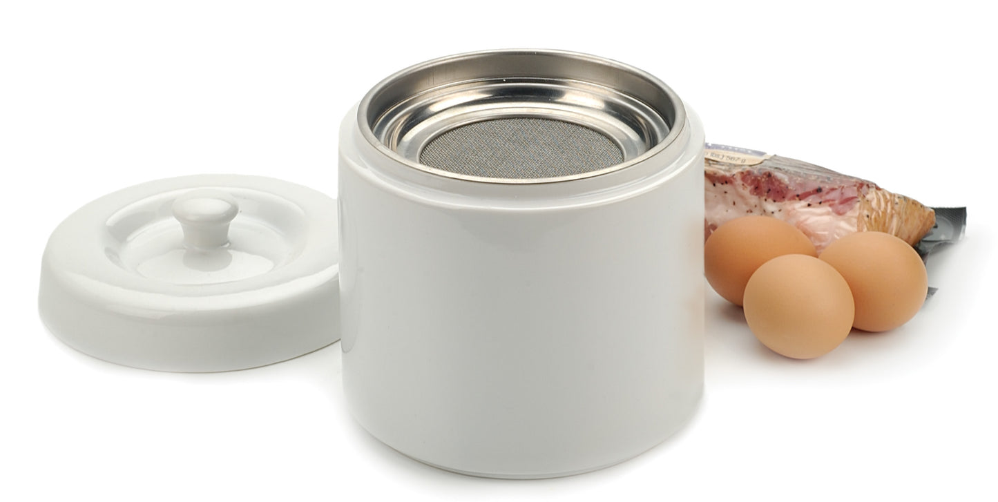grease keeper with lid, eggs, and bacon next to it.